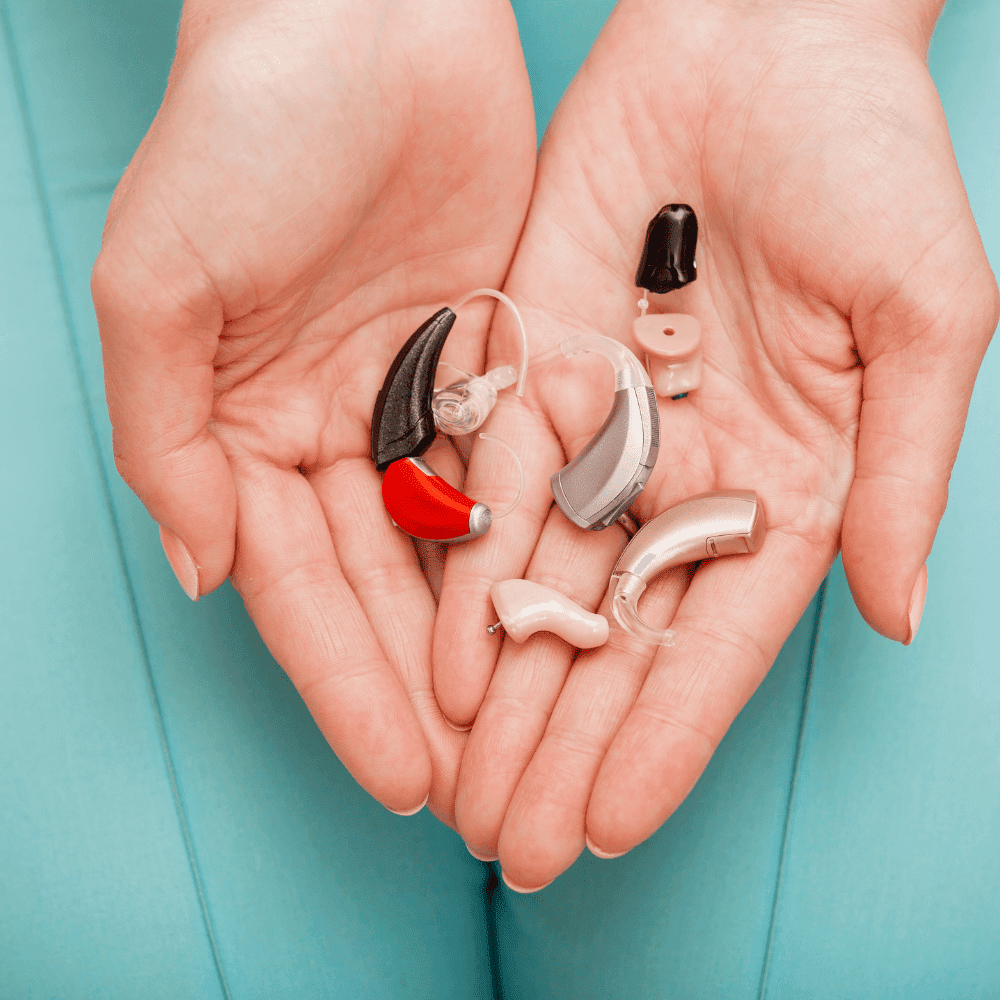 audiologist holding many hearing aids